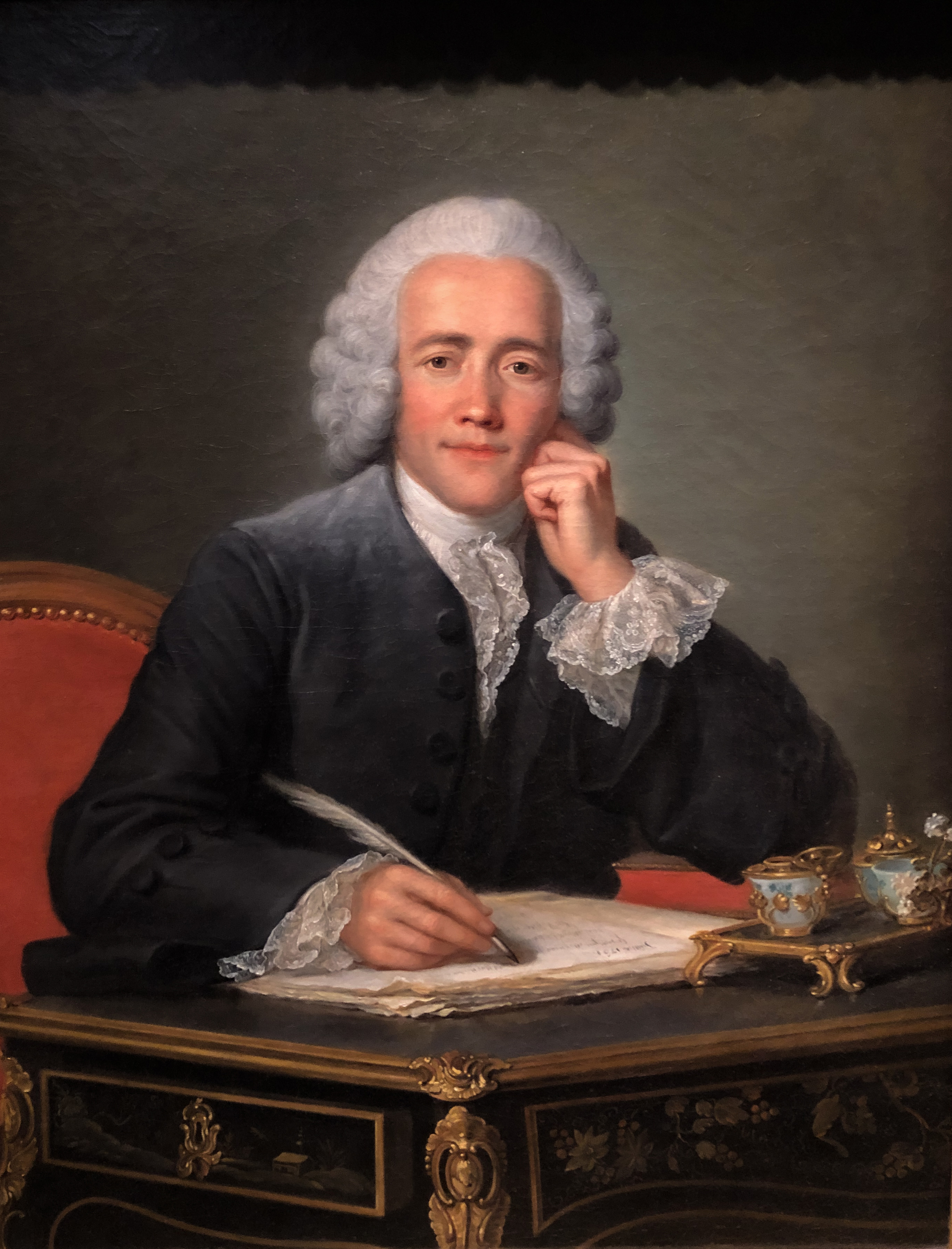 Jeff Ammons smiling in a blazer with a vintage typewriter and stack of notebooks.